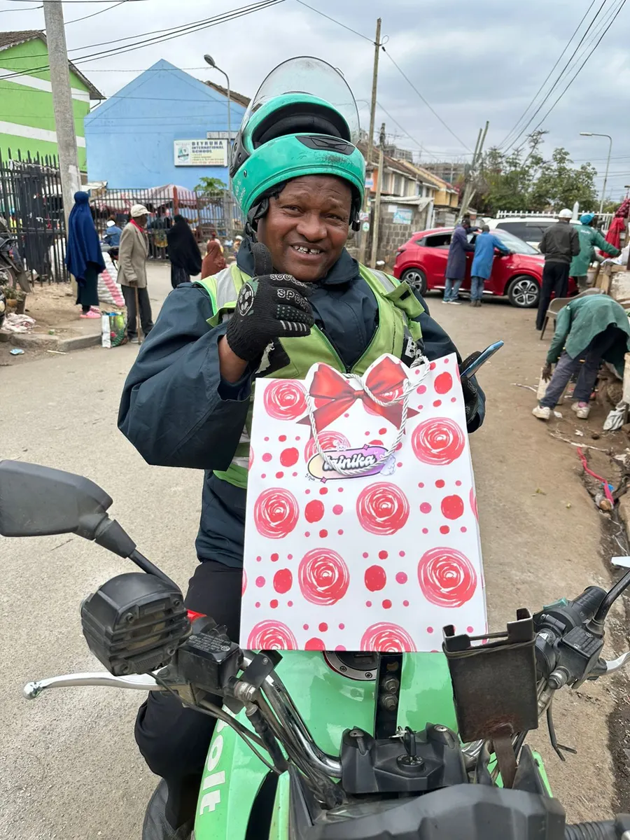 Delivery driver smiling while holding a Lainika bag