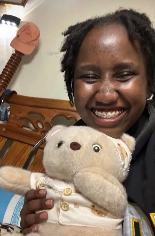 Girl cuddling her Lainika Bear plushie